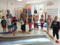 Dzieci i opiekunowie w sali gimnastycznej