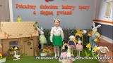 dziewczynka stoi w otoczeniu makiet domu i figur zwiazanych z wiosną