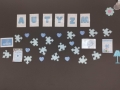 Wycięty z papieru napis "Autyzm" oraz błękitne puzzle na ciemnym tle.
