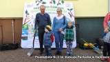 dzieci z dziadkami przy banerze promującym nasadzenia roślin