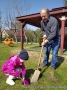 dziewczynka z dziadkiem sadzą roślinkę