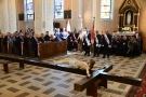zgromadzeni w kościele goście oraz leżący na ziemi duży drewniany krzyż z figurą Chrystusa