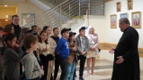 po lewiej stronie grupa zwiedzająca, po prawej duchowny - dyrektor festiwalu