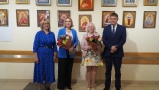 Trzy kobiety i mężczyzna pozują do zdjęcia przy wystawie ikon