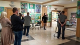 Telewisja kablowa przeprowadza wywiad z laureatka konkursu. W tle widać prace konkursowe.