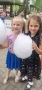 dwie dziewczynki trzymające w rękach balony