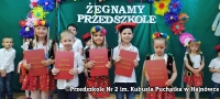 przedszkolaki w strojach krakowskich trzymające w rękuczerwone dyplomy