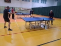 mężczyźni grający w tenisa stołowego na sali gimnastycznej