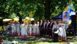 zespół ludowy w biało-czerwonych strojach podczas występu w plenerze