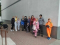 grupa osób pozje do zdjęcia przy scianie budynkku