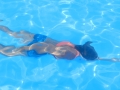 Uczestnik płynie całkowicie zanurzony pod wodą.