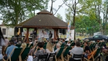 uczestnicy jarmarku siedzący na leżakach i przysłuchujący się występom