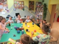 Dzieci owijają książki włóczką.
