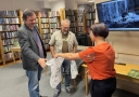 wręczenie upominków przez pracowniće biblioteki dla dwóch mężczyzn
