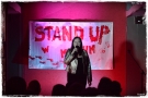 kobieta z mikrofonem. W tle widać podświetlony napis STAND UP 