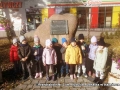 dzieci stoją przy pomniku