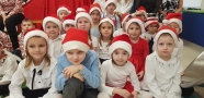grupa dzieci w czapeczkach mikołajkowch
