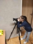 dziewczyka patrzy prez aparat fotograficzny na statywie
