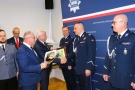 burmistrz i starosta składają gratulacje mężczyżnie w mundurze