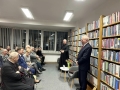 duchowny i autor książki premawiają do publiczności w czytelni miejskiej
