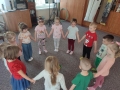 dzieci trzymają się za ręce i stoją k kółku