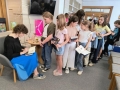 kobieta składa dzieciom autografy