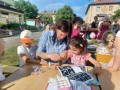 dzieci bawiące się na przedszkolnym placu zabaw. Przedszkolaki biorą udział w zabawach, łapią bańki, robią tatuaże, malują swoje twarze, bawią się kolorowymi balonami