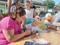 dzieci bawiące się na przedszkolnym placu zabaw. Przedszkolaki biorą udział w zabawach, łapią bańki, robią tatuaże, malują swoje twarze, bawią się kolorowymi balonami