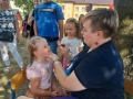 dzieci bawiące się na przedszkolnym placu zabaw. Przedszkolaki biorą udział w zabawach, łapią bańki, robią tatuaże, malują swoje twarze, bawią się kolorowymi balonami