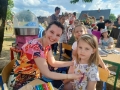 dzieci bawiące się na przedszkolnym placu zabaw. Przedszkolaki biorą udział w zabawach, łapią bańki, robią tatuaże, malują swoje twarze, bawią się kolorowymi balonami