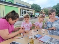 dzieci bawiące się na przedszkolnym placu zabaw. Przedszkolaki biorą udział w zabawach, łapią bańki, robią tatuaże, malują swoje twarze, bawią się kolorowymi balonami
