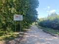 zdjęcie trwajacej inwestycji drogowej wraz z tablicą informacyjną o dofinansowaniu