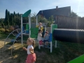 dzieci znajdują się w ogrodzie przedszkolnym, bawią się na nowych urządzeniach terenowych.