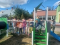 dzieci znajdują się w ogrodzie przedszkolnym, bawią się na nowych urządzeniach terenowych.