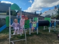 dzieci znajdują się w ogrodzie przedszkolnym, bawią się na nowych urządzeniach terenowych.