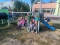 dzieci znajdują się w ogrodzie przedszkolnym, bawią się na nowych urządzeniach terenowych.