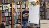 mężczyzna przy tablicy, na której naryskowane sa postacie z bajki