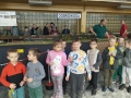 dzieci oglądają makiety z miniaturami torów, pociągów i stacji kolejowych