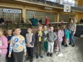 dzieci oglądają makiety z miniaturami torów, pociągów i stacji kolejowych