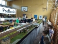 dzieci oglądają makiety z miniaturami torów, pociągów i stacji kolejowych