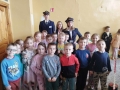 dzieci oglądają makiety z miniaturami torów, pociągów i stacji kolejowych