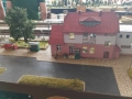 dzieci oglądają makiety z miniaturami torów, pociągów i stacji kolejowych
