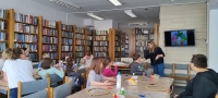 uczestnicy warsztatów siedzą przy stole i wykonują ozdoby