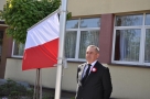 mężczyzna stoi przy fladze państwowej