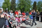 burmistrz i zastępca wręczają dzieciom słodkie upominki