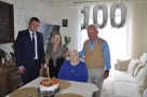 Jubilatka, jej córka i syn oraz burmistrz pozują do zdjęcia. W tle widać balony z cyfrą 100