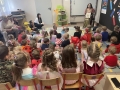  nauczycielka oraz dzieci w trakcie czytania, wszyscy są przebrani za postacie bajkowe.