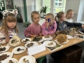 Dzieci i nauczycielka oglądają małe okazy przez lupę.