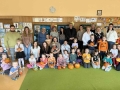 dziec, rodzice i nauczycielki pozują do zdjęcia. Dzieci trymaja dekoracje z dyni.