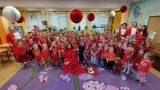 Wszyscy uczestnicy kampanii pozują do zdjęcia. Dzieci oraz kadra pedagogiczna jest ubrana na czerwono. Czerwony jest kolorem kampanii.